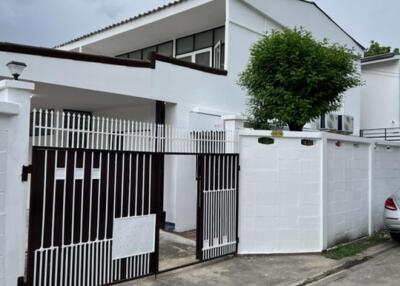 Front view of a modern white house with a gated entrance