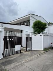 Front view of a modern white house with a gated entrance