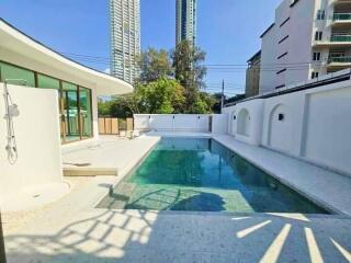 Modern outdoor swimming pool area with surrounding buildings