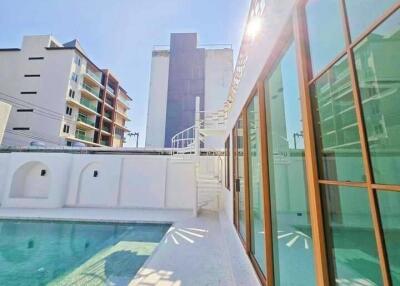 Luxurious outdoor pool area with modern building in background