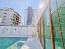 Luxurious outdoor pool area with modern building in background