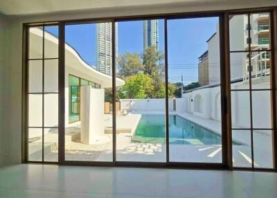 Living room with glass sliding doors overlooking a swimming pool and modern architecture