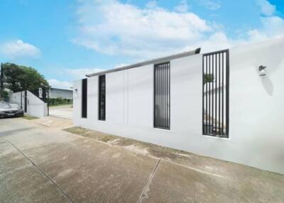 Exterior view of a modern building with white walls and vertical black window grilles