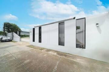 Exterior view of a modern building with white walls and vertical black window grilles