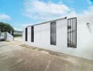 Exterior view of a modern building with white walls and vertical black window grilles