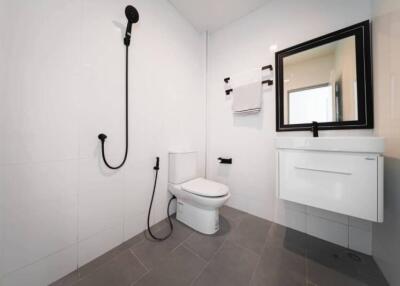 Modern bathroom with white tiles, black fixtures, and a floating vanity