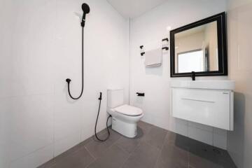 Modern bathroom with white tiles, black fixtures, and a floating vanity