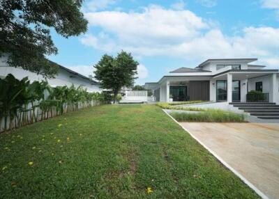 Exterior view of a modern house with a lawn and driveway