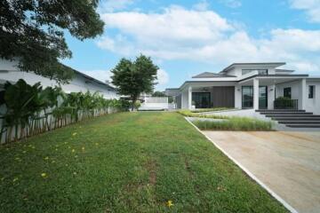 Exterior view of a modern house with a lawn and driveway