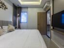 Modern bedroom with bed, wall-mounted TV, and air conditioning