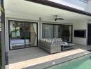 Covered patio with couch and coffee table overlooking pool