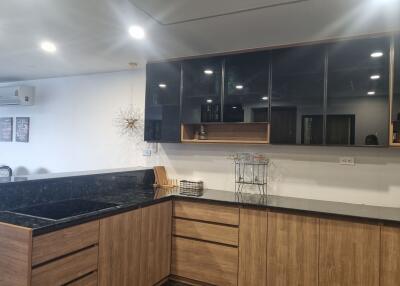 Modern kitchen with wooden cabinetry and black countertops