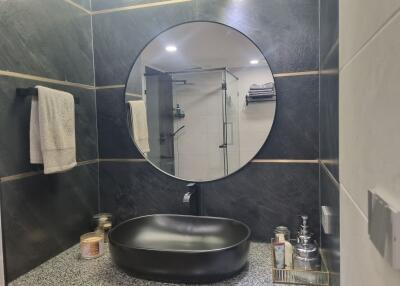 Modern bathroom with round mirror and stylish black sink