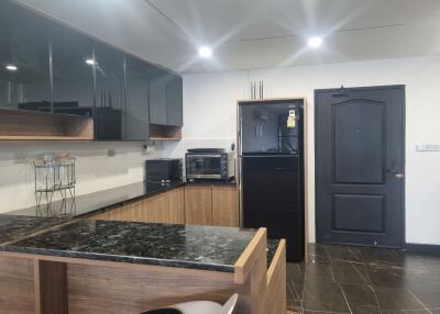 Modern kitchen with black and wooden cabinets and appliances