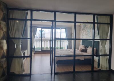 Modern bedroom with glass wall and balcony view