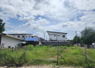 Vacant lot with two houses in the background