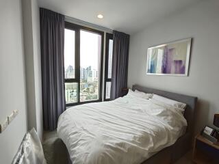 Well-lit bedroom with large window and city view