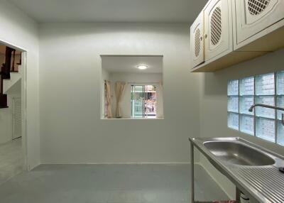 Small kitchen with a window, sink, and cabinets