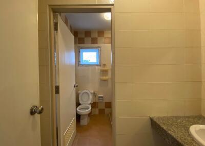 Bathroom with toilet, small window, and sink