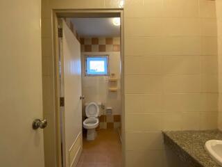 Bathroom with toilet, small window, and sink