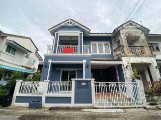 Two-story modern house with a balcony and gated driveway