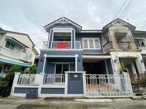 Two-story modern house with a balcony and gated driveway