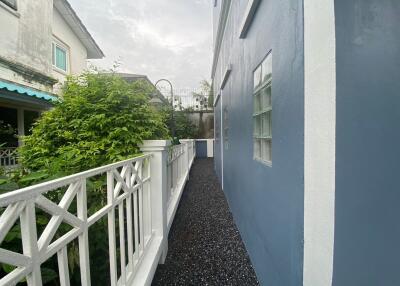 Side walkway with blue wall and white fence