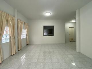 Spacious living room with tiled flooring and large windows