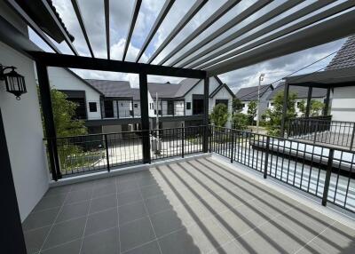 Modern balcony with open slatted roof and view of surrounding houses