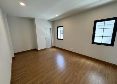 Empty bedroom with wooden flooring and windows