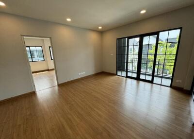 Spacious modern living area with wooden flooring and large windows