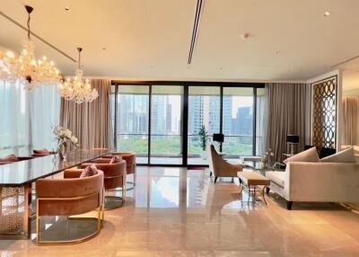 Spacious and luxurious living room with large windows, chandeliers, and modern decor