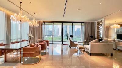 Spacious and luxurious living room with large windows, chandeliers, and modern decor