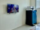 Modern living room with air conditioner, mounted TV, and a refrigerator