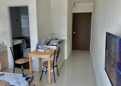 Living area with dining table and kitchenette in a compact studio apartment