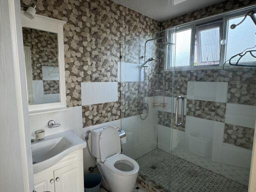 Bathroom with a white sink, toilet, and glass-enclosed shower area