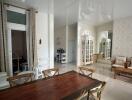 Living and dining area with wooden furniture and large mirror