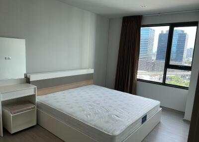 Bedroom with a bed, vanity table, and city view