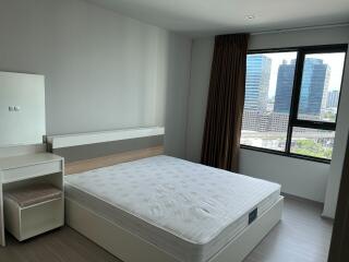 Bedroom with a bed, vanity table, and city view