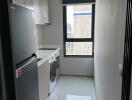 Laundry room with washer, dryer, cabinets, and natural light