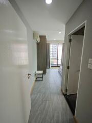 Modern apartment bedroom with grey floor tiles, built-in air conditioner, and large window