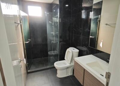 Modern bathroom with a glass-enclosed shower, toilet, and vanity