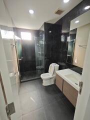 Modern bathroom with a glass-enclosed shower, toilet, and vanity