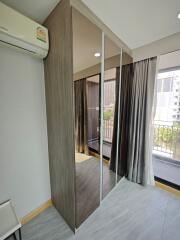 Modern bedroom with mirrored wardrobe and large windows