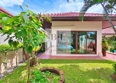 Outdoor area with well-maintained garden and a house with a red roof