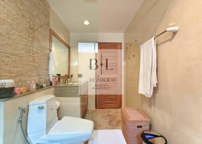 Modern bathroom with vanity, toilet, and shower area