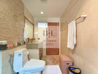 Modern bathroom with vanity, toilet, and shower area