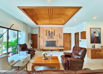 Spacious living room with wooden ceiling and leather furniture