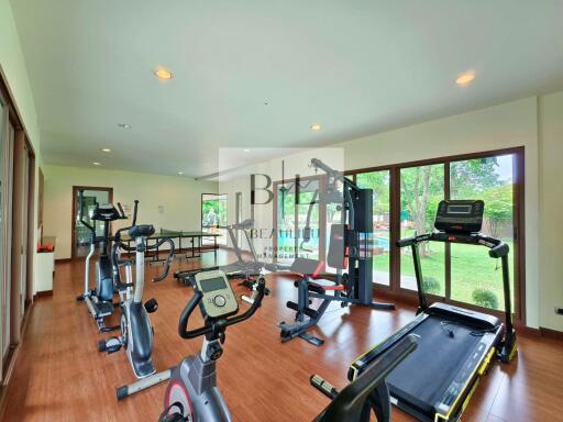 Well-equipped gym with modern exercise machines and large windows.