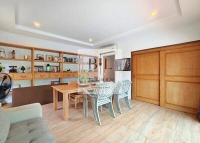 Spacious main living area with wooden shelves, table, and chairs